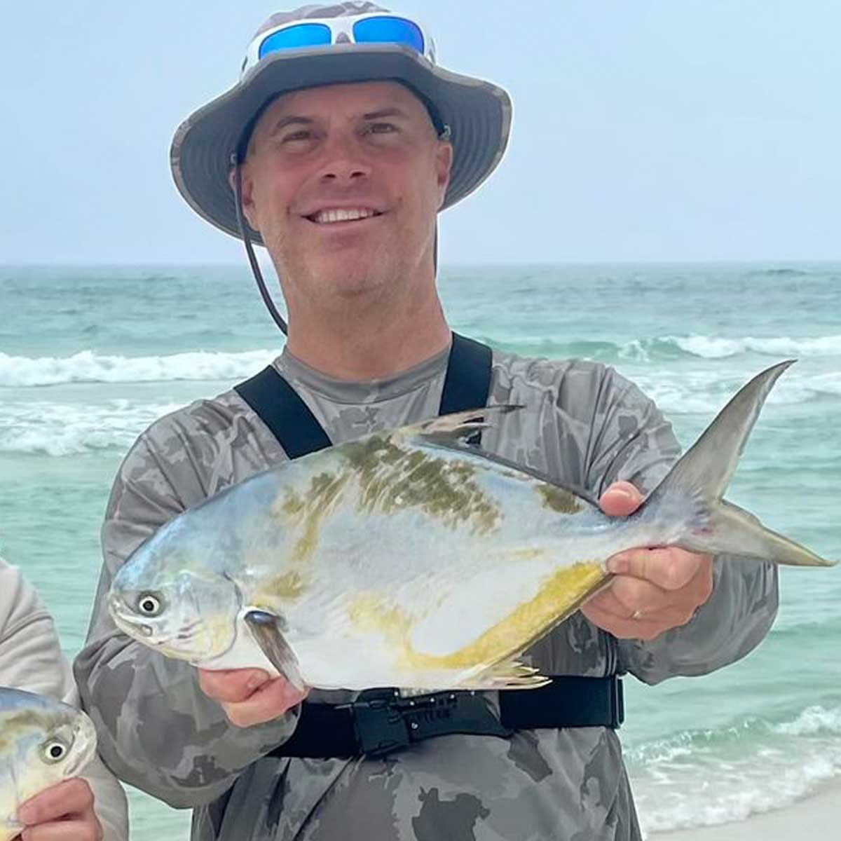 picture of a man wearing a shelta sun hat and wearing an aquaterra sun shirt in camo