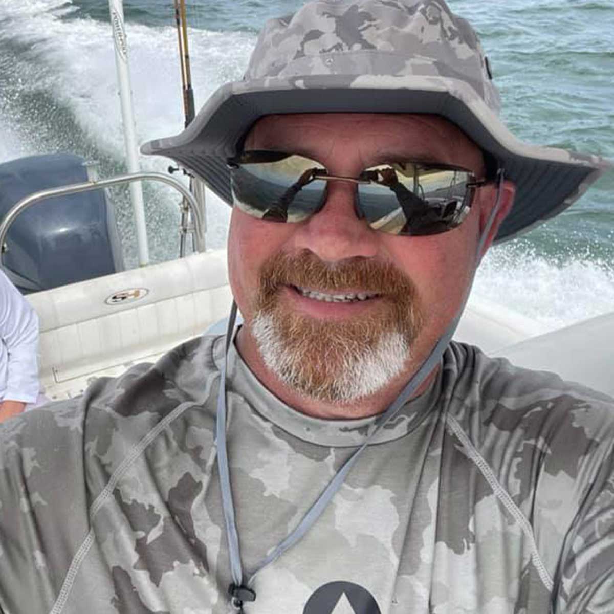 a picture of a man on a boat wearing a shelta sun hat and aquaterra sun shirt